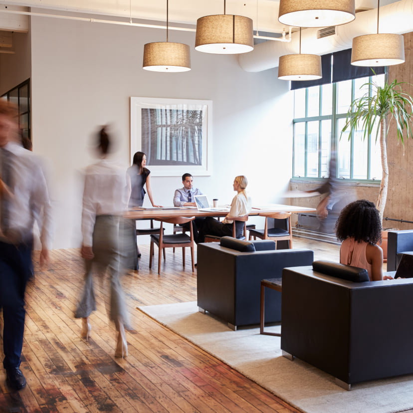 Workers walking and collaborating in an office setting.